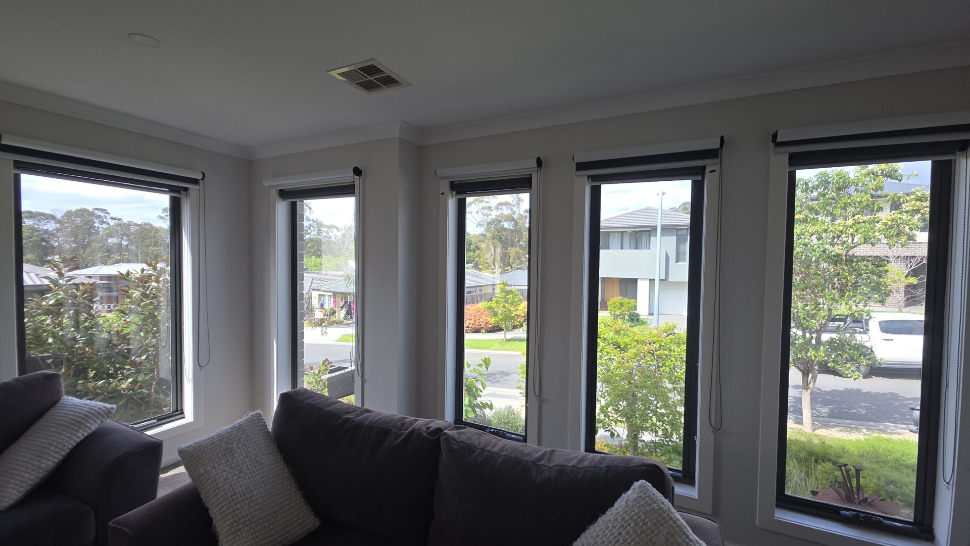 Living room with a row of tall windows and furniture placed in front of the glass