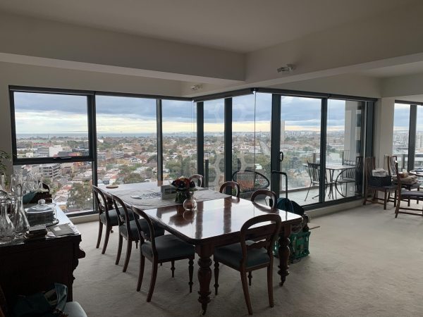 Professional installer applying 3M window film to a Melbourne home window