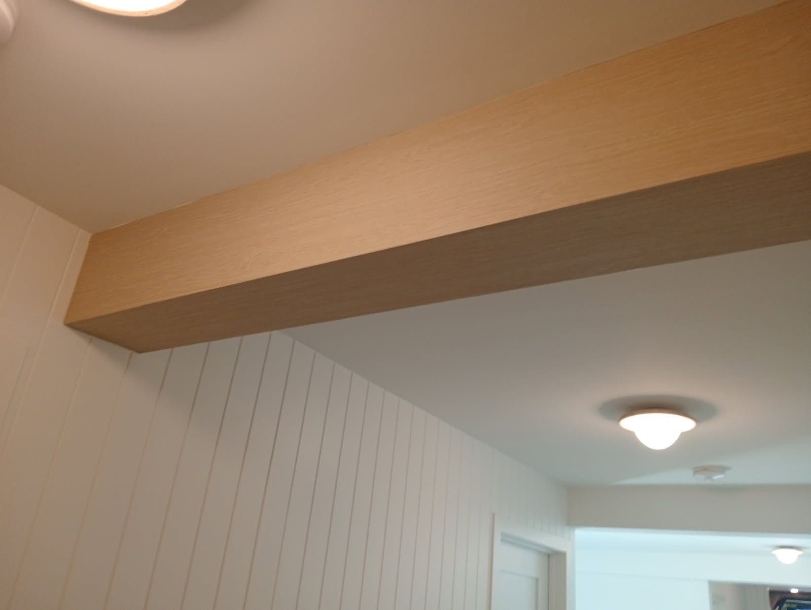 Close view of the grain and wrapped edges on an oak look architectural vinyl beam