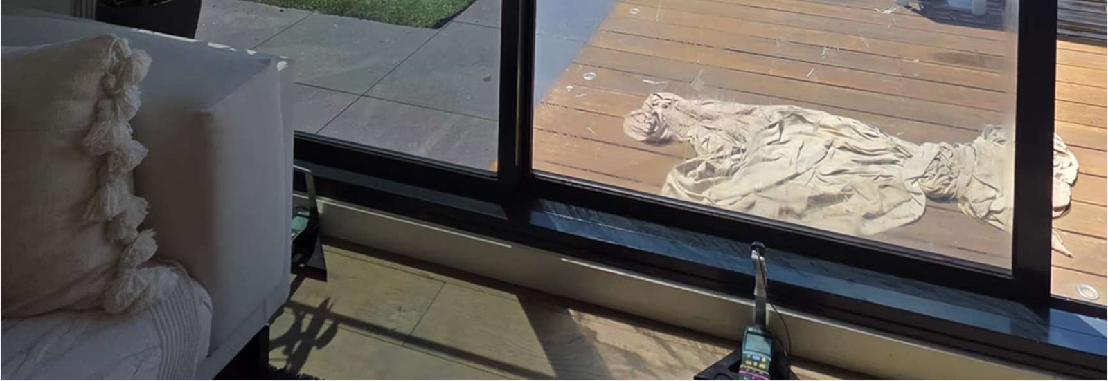 Close-up of the data-logging BTU meter and sensor mounted behind a filmed pane
