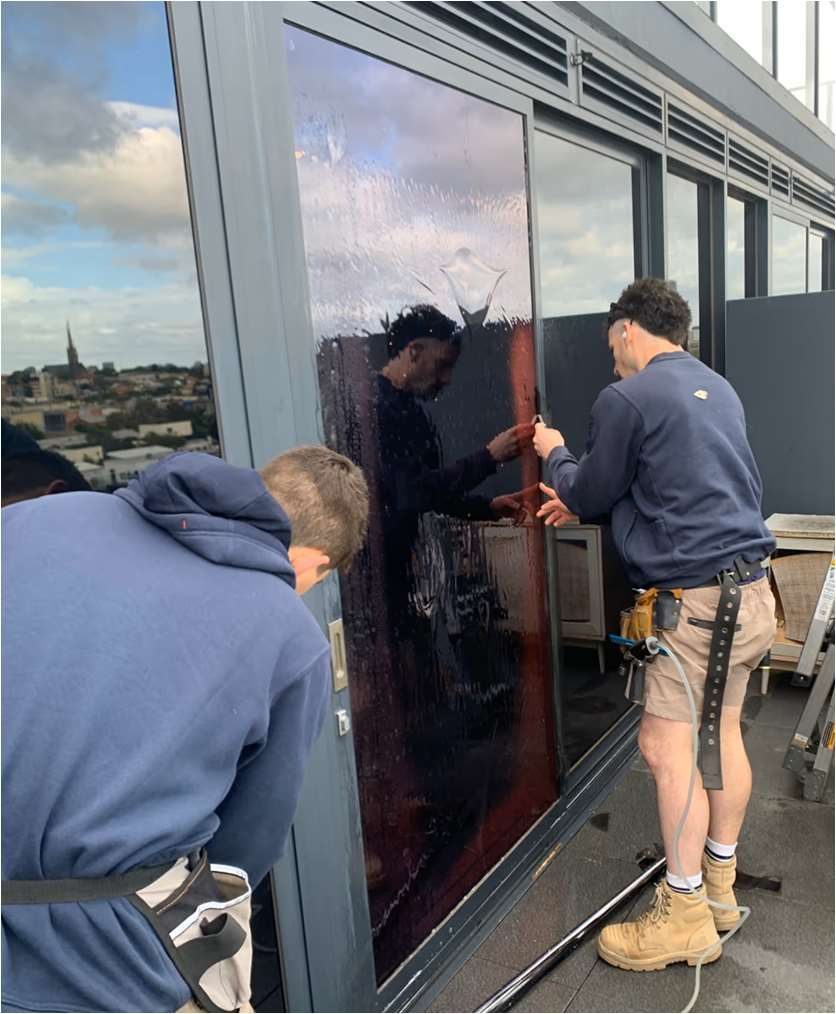 Installation team applying 3M Prestige 40 Exterior film on a high-rise pane on-site