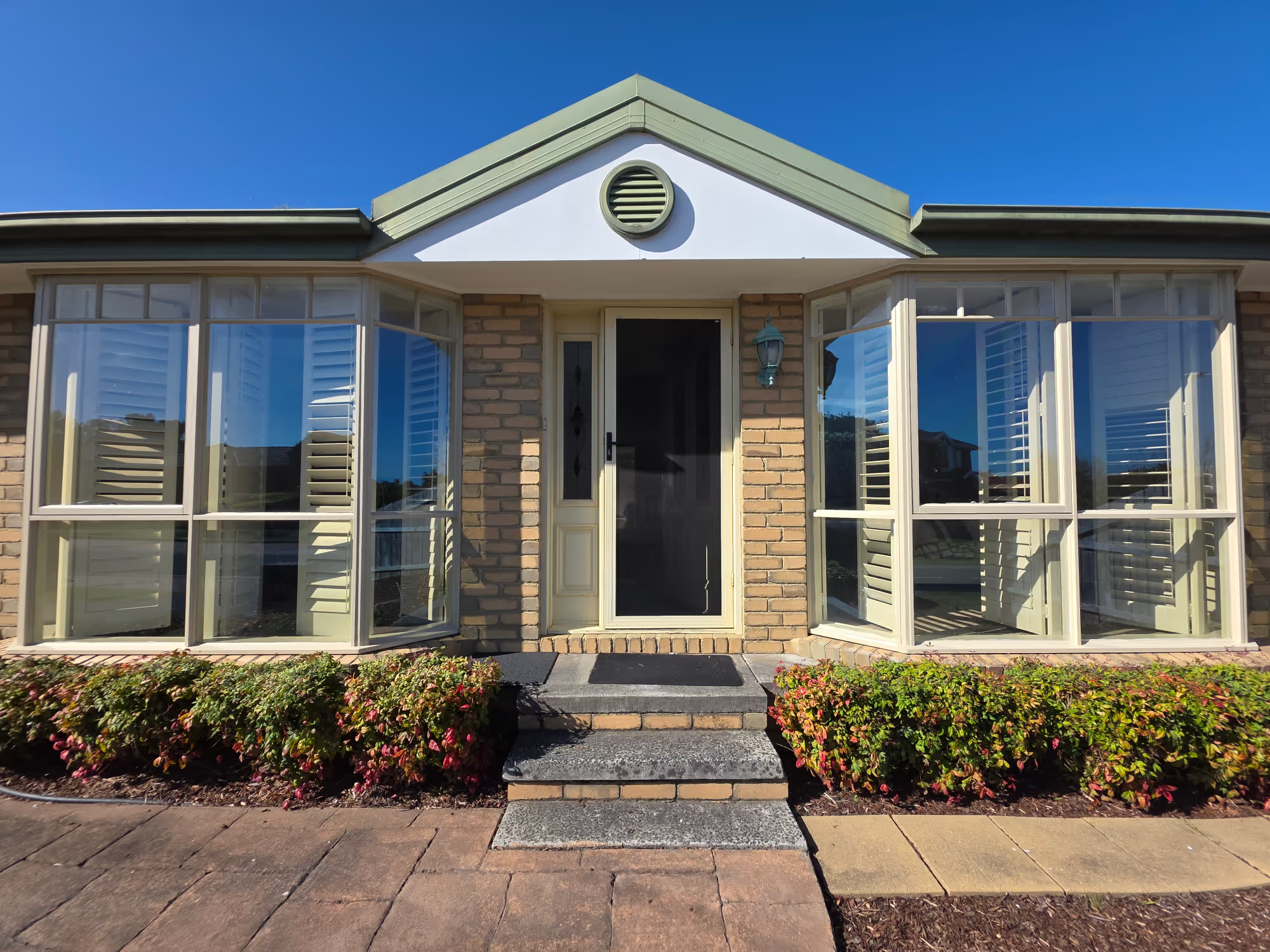 Solar Gard Ecolux 70 window film installed on bay windows with white plantation shutters